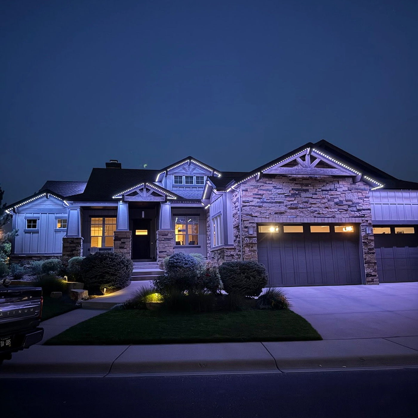 Home with warm-white permanent roofline lighting at twilight