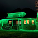 Wraparound-porch home bathed in bright green permanent LED lighting