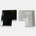 Close-up of black and white permanent LED track corner connectors on a light gray background