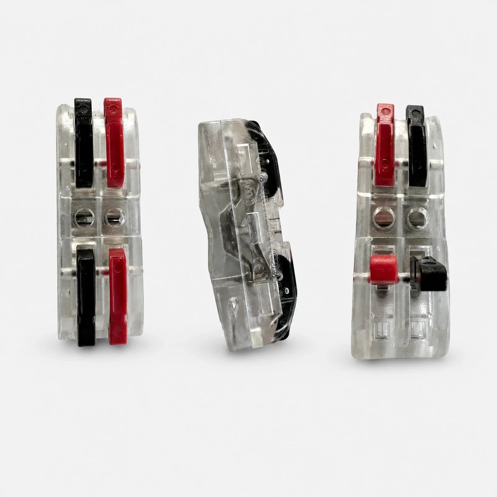 Three views of a transparent 2-port lever wire connector with red and black levers
