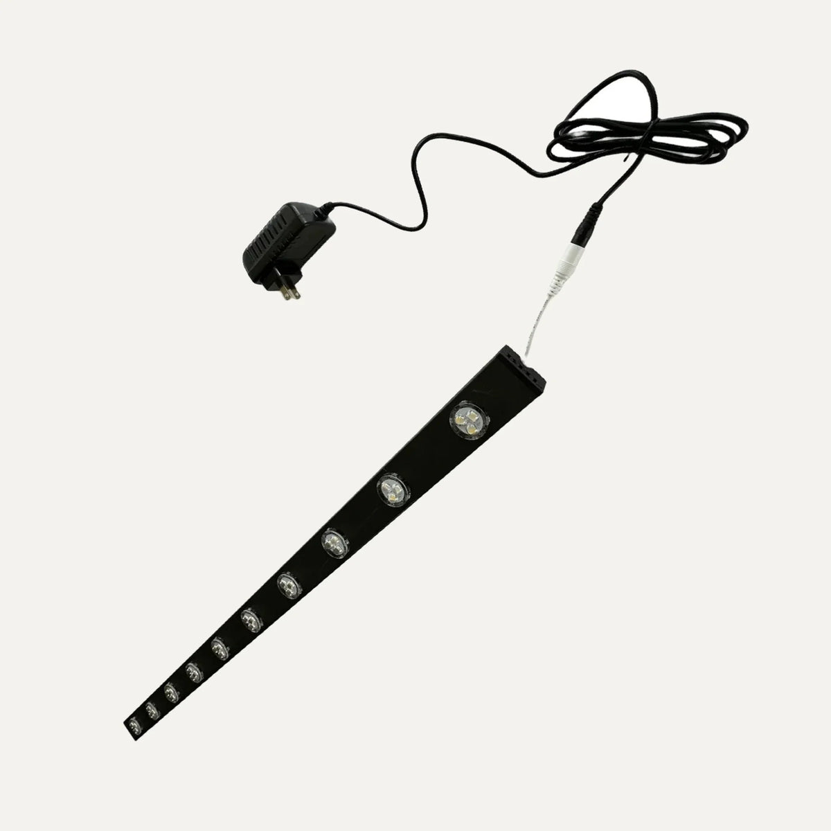 Black permanent LED demo track with ten puck lights, power adapter, and connection cable