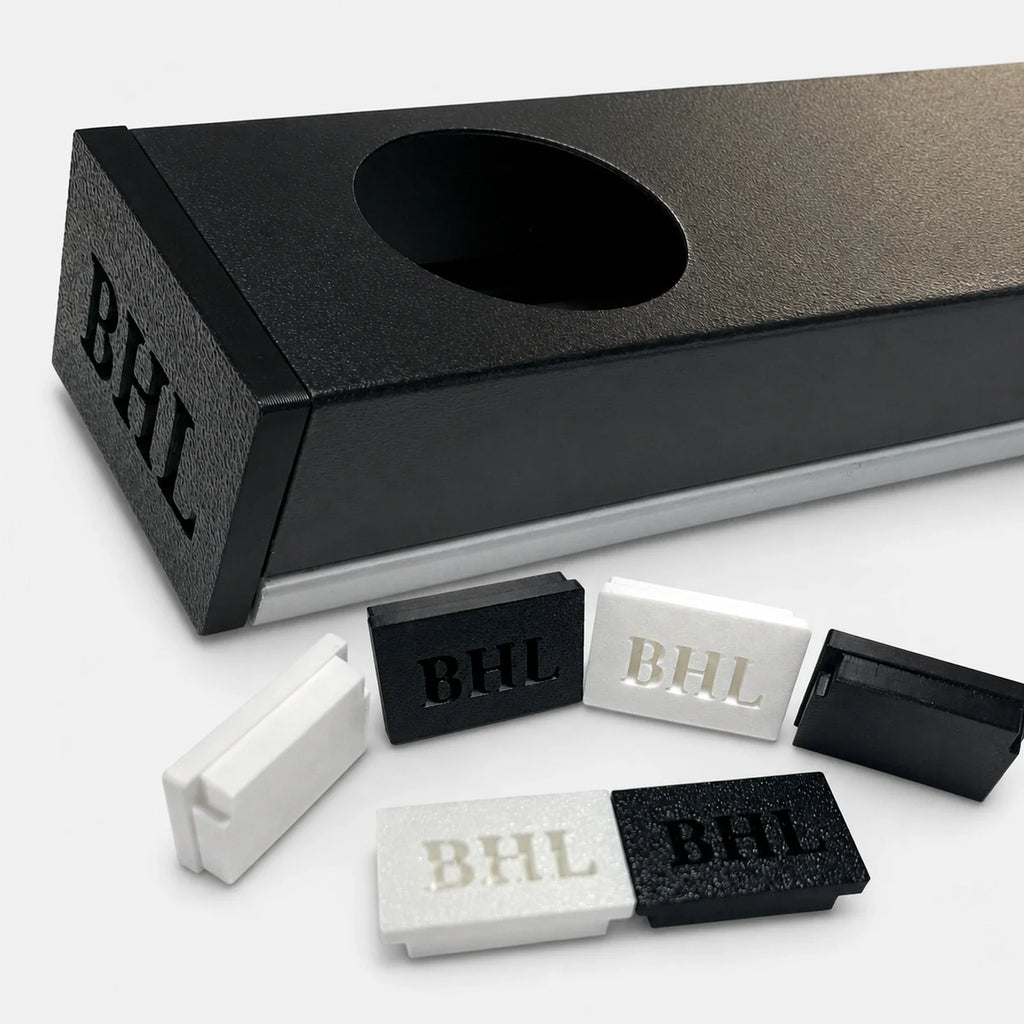 Close-up of a black permanent LED track with installed end cap and loose black and white end caps