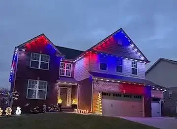 Two-story home with blue, red, and white permanent LED roofline lights