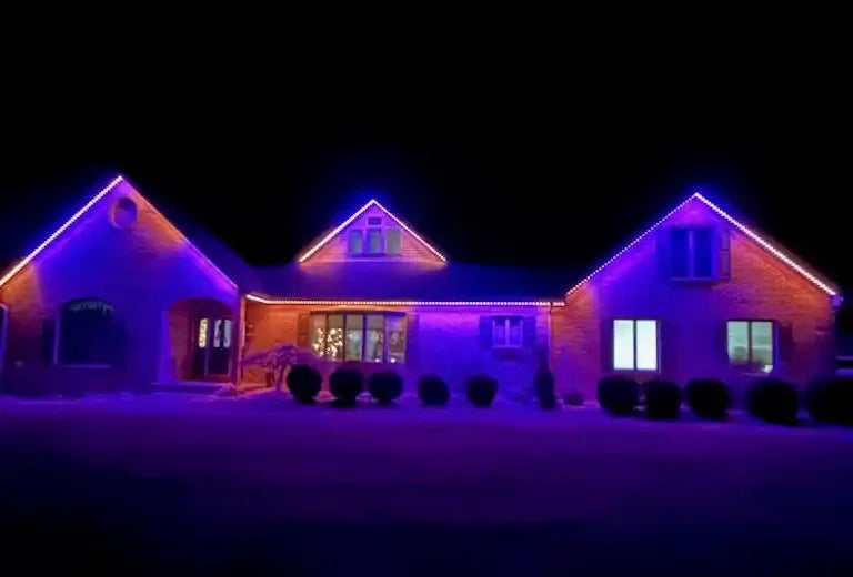 Wide brick home illuminated with purple permanent roofline lights