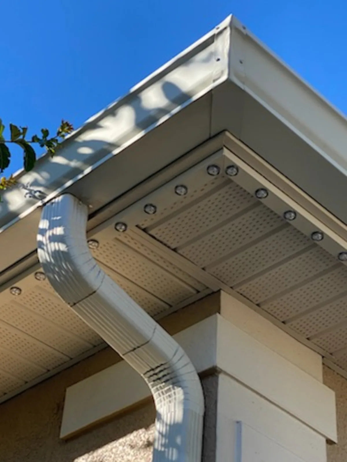 Permanent puck lights installed beneath a soffit and routed around an outside corner