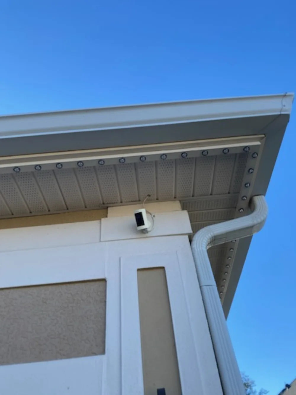 Permanent lighting track continuing around a roofline corner with wiring concealed